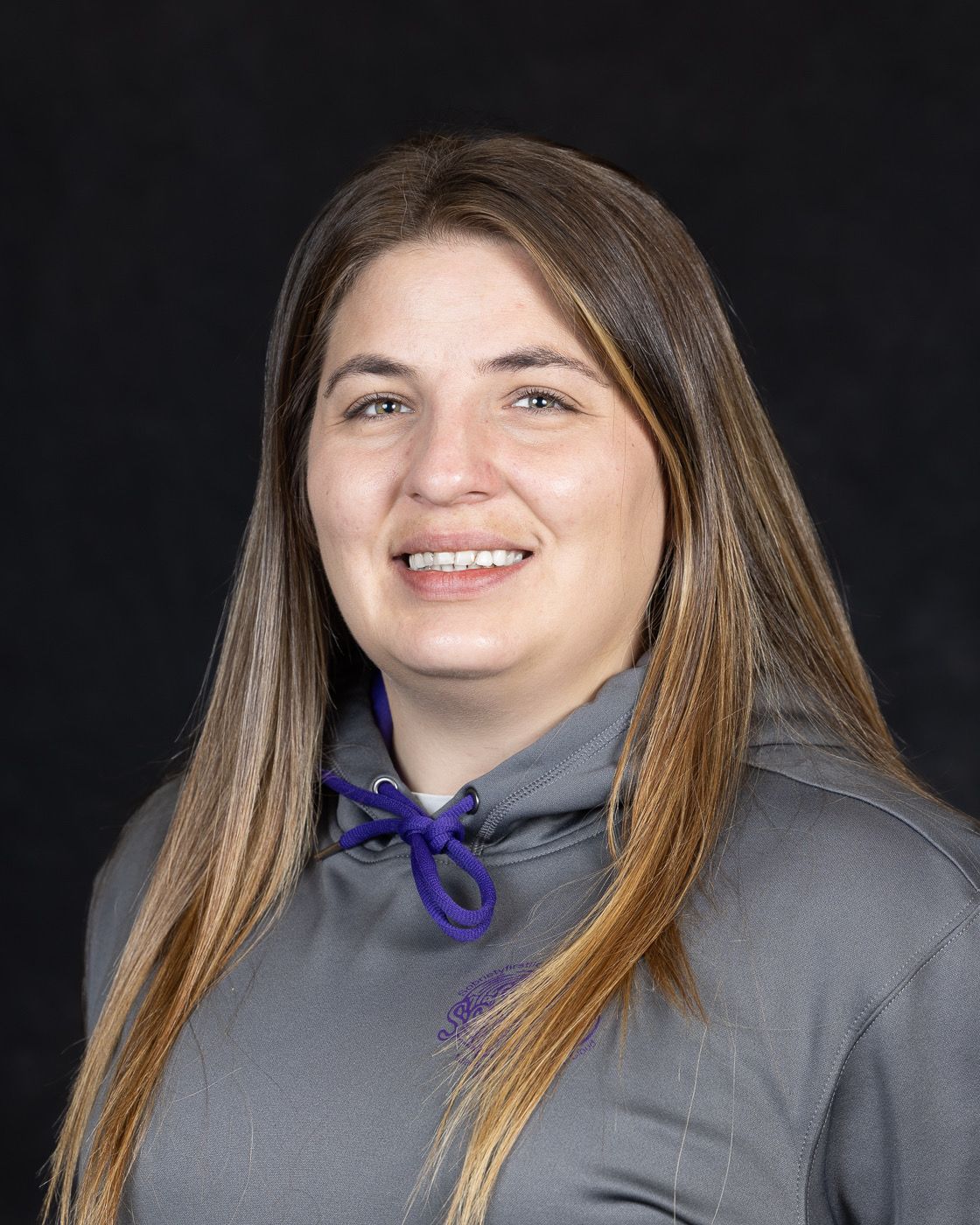 An addiction education counselor wearing a red jacket and a necklace is smiling for the camera.