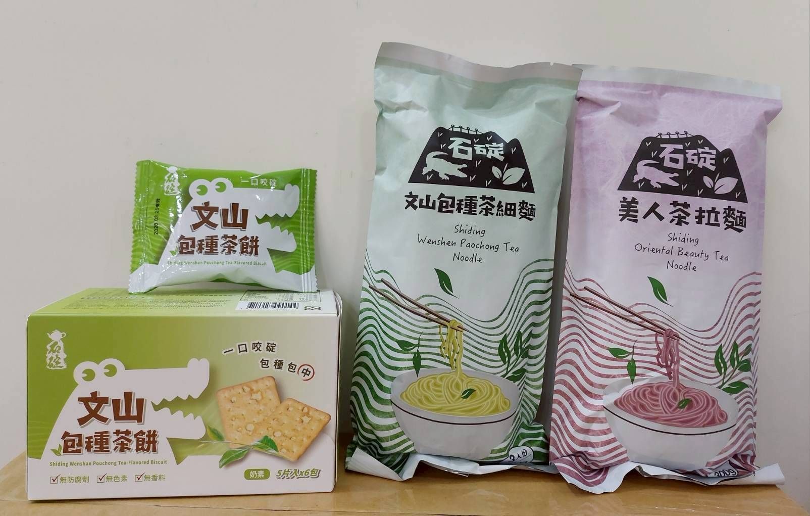 一群人站在舞台上舉著紅色橫幅，對著鏡頭微笑。