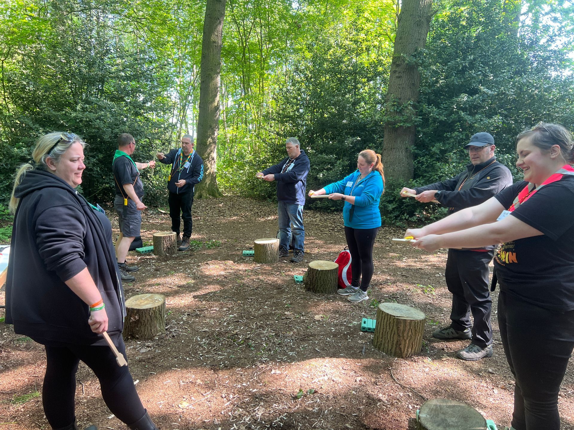 Adults learning knife skills stood up in a woodland