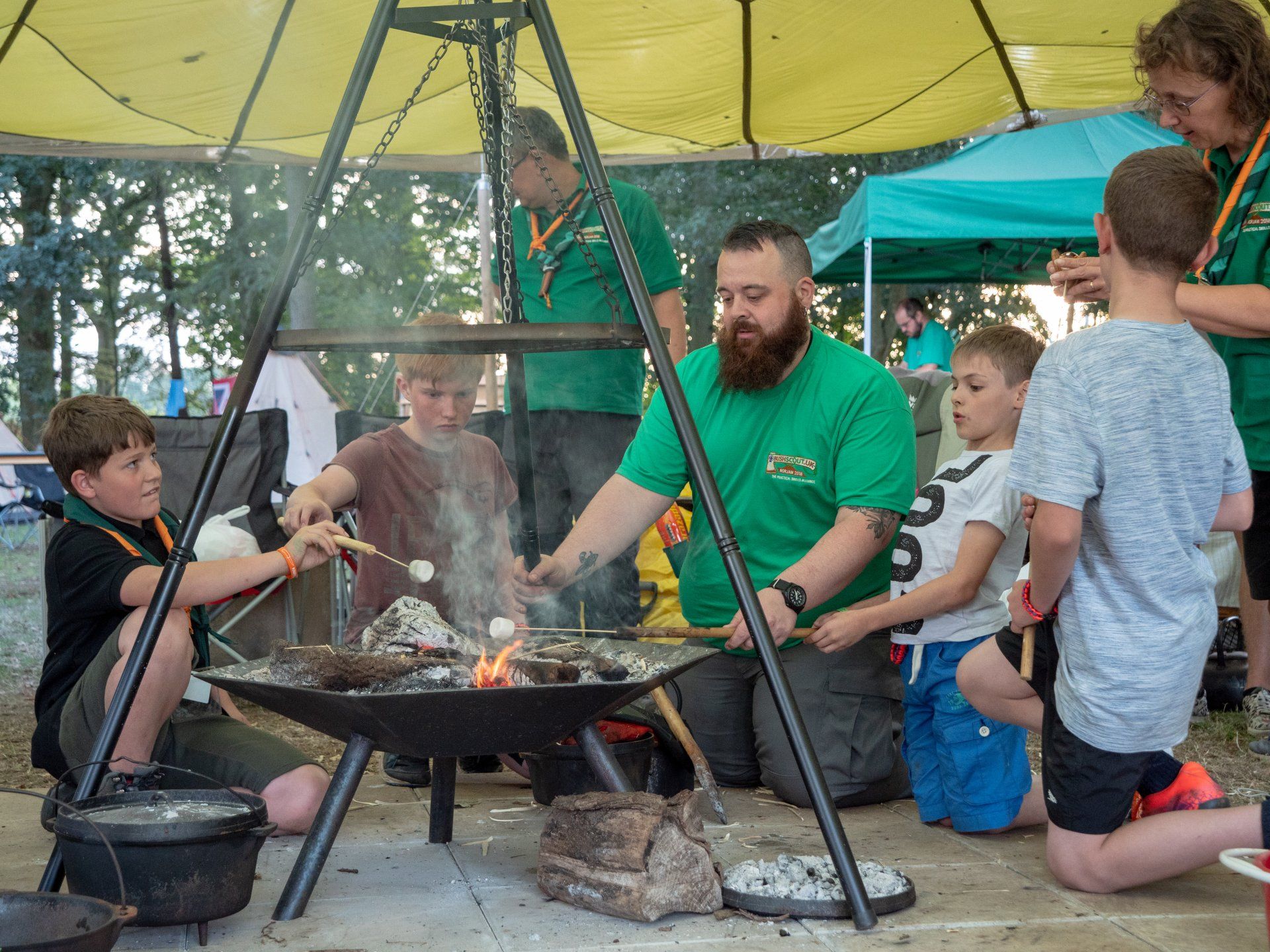 Young people toasting marshmallows over a fire pit