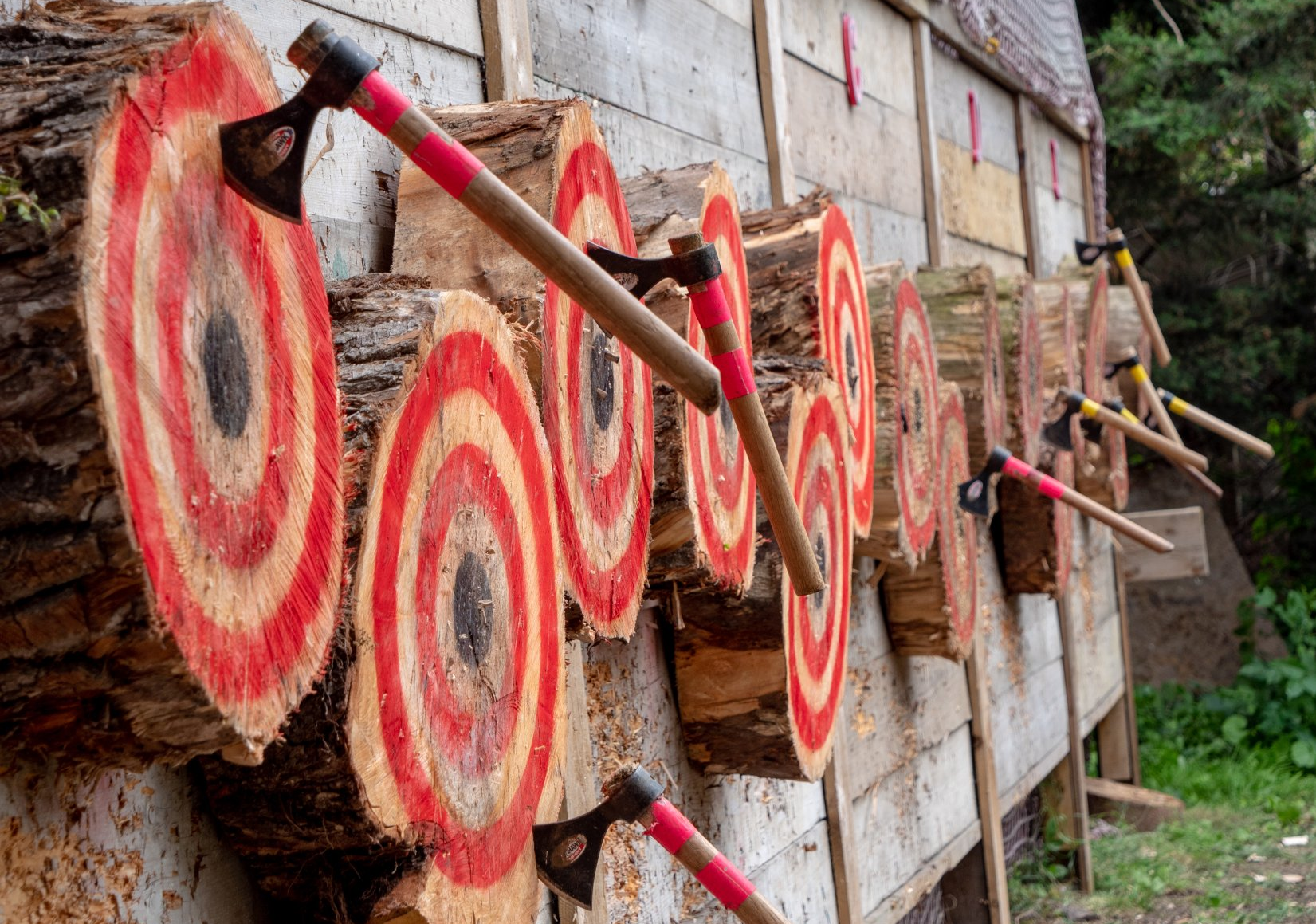 Wooden tomahawk targets with red circles and tomahawks embedded