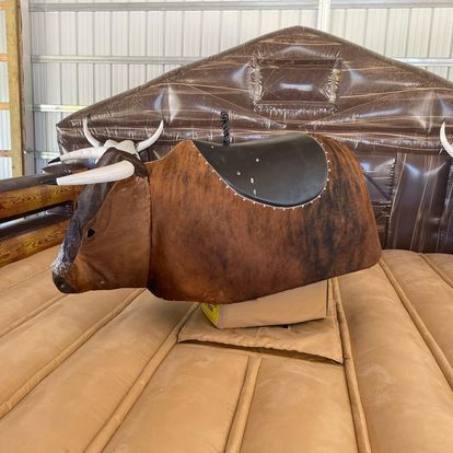 A mechanical bull is sitting on top of a wooden table.