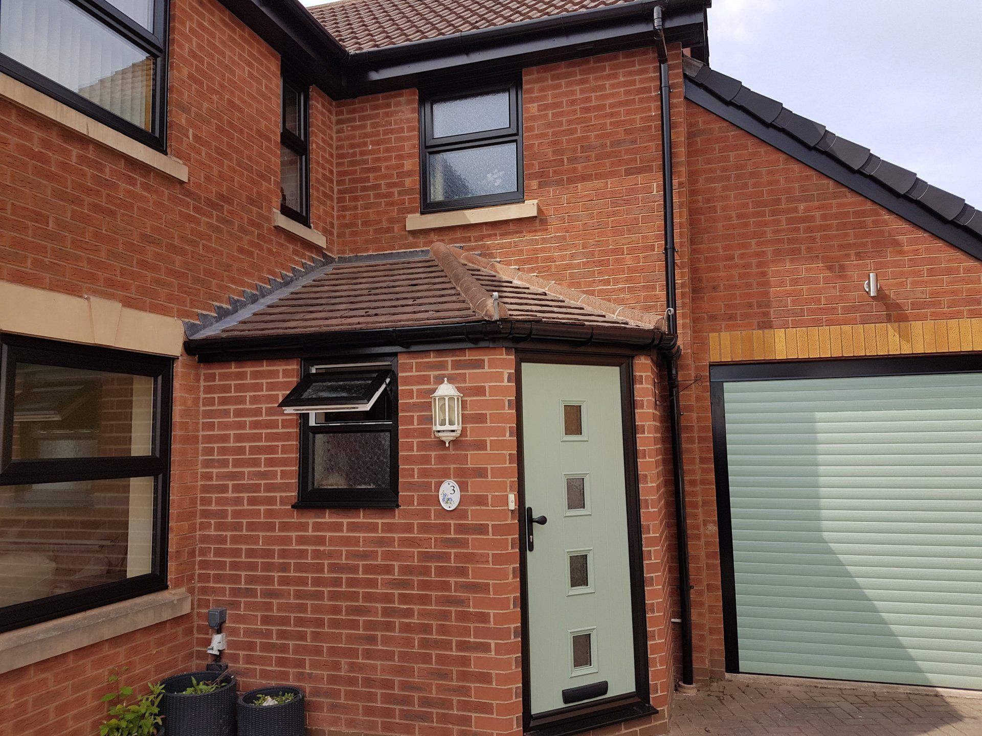 House-Black fascia, black/brown windows, composite doors and a new garage door in Chartwell Green