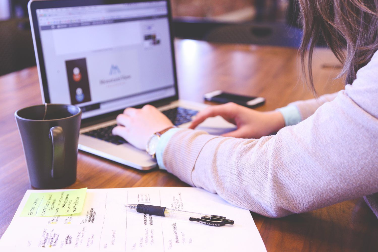 a woman is sitting at a table using a laptop computer .