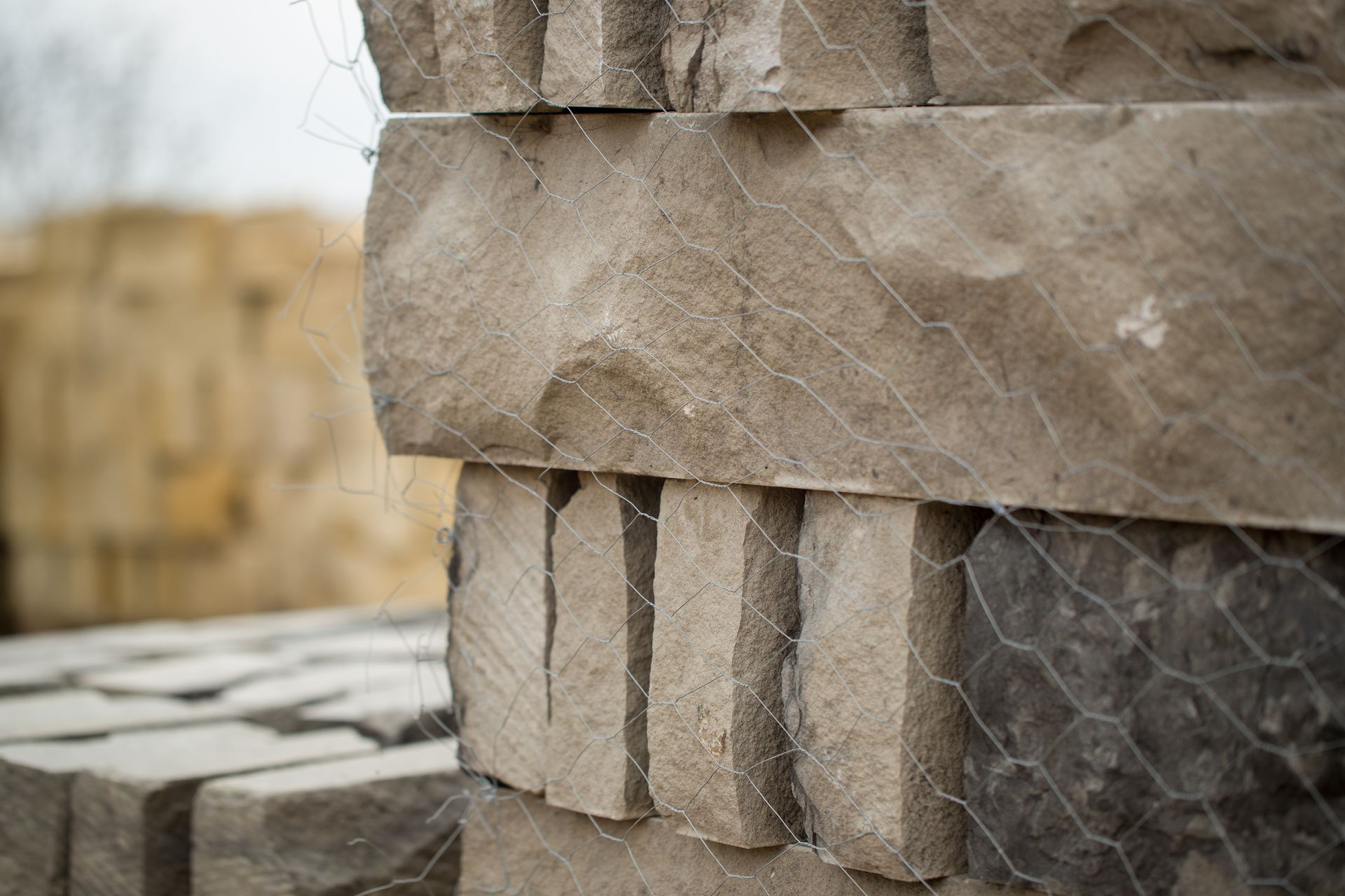 a stack of bricks behind a chicken wire fence