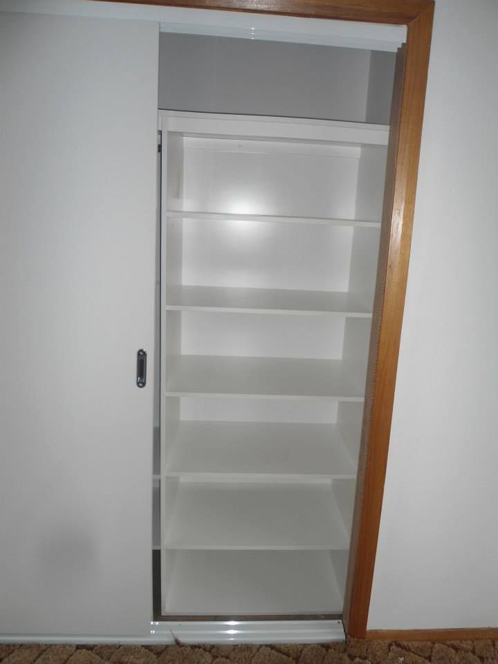 A closet with shelves and a sliding door