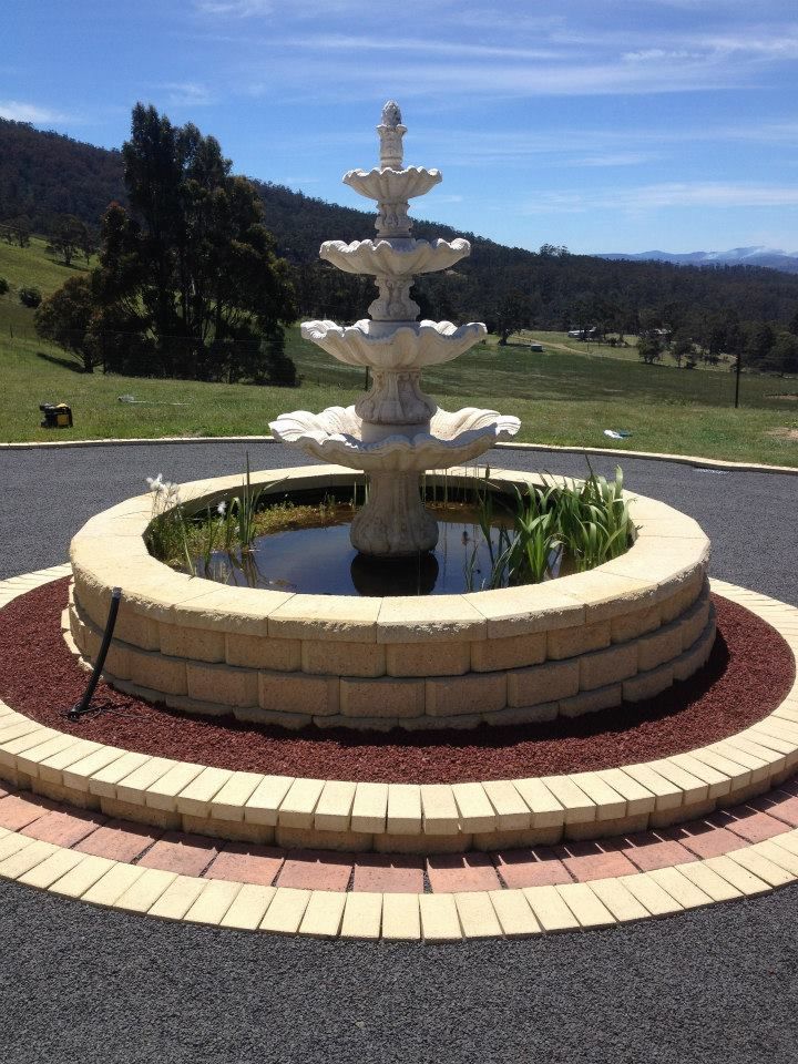 A fountain with a pond in the middle of it