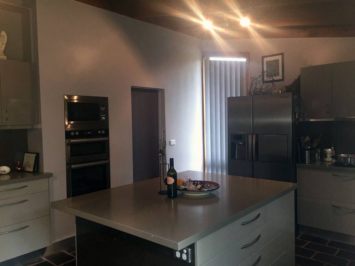 A kitchen with a large island and a bottle of wine on it