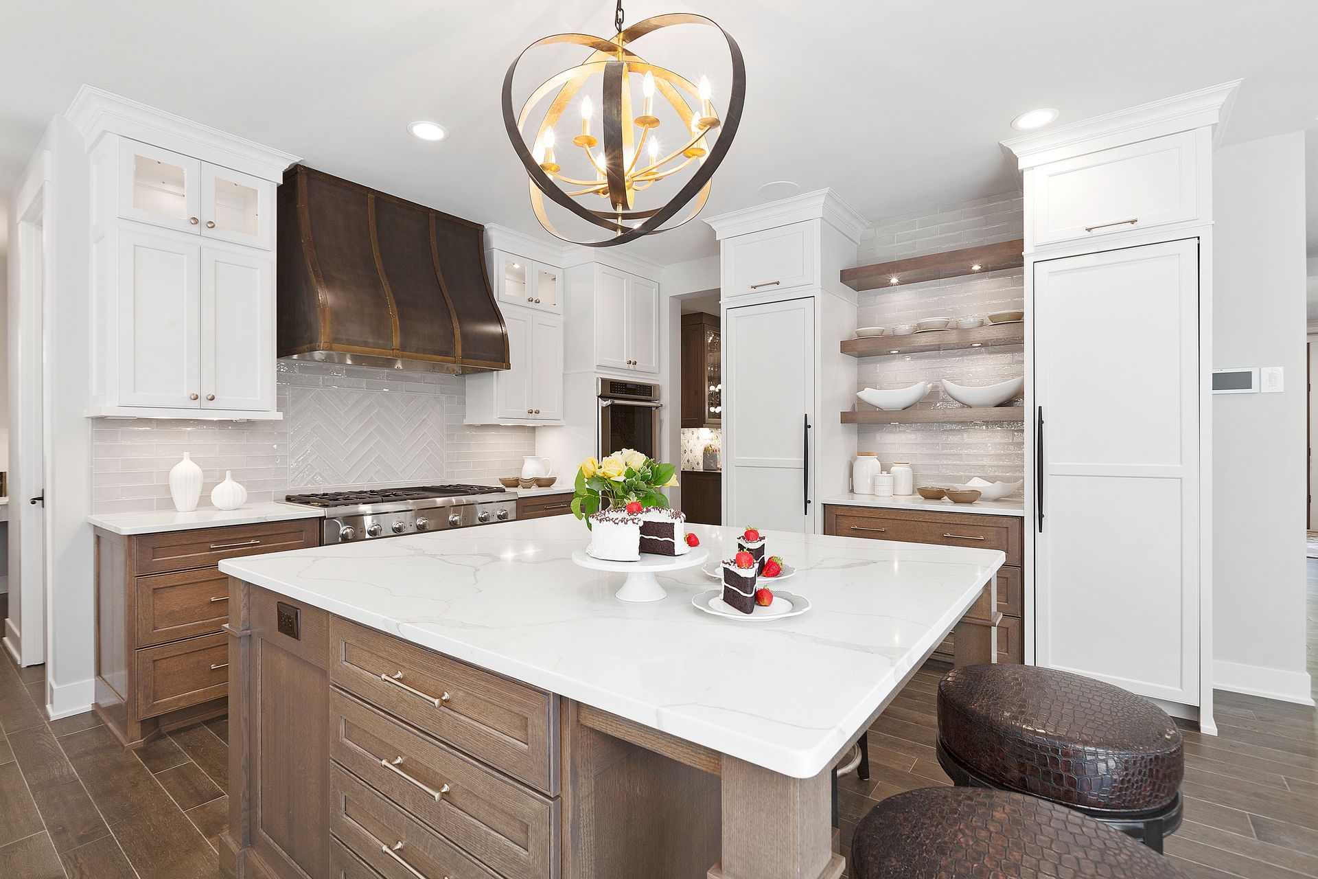 A kitchen with a large island in the middle and a chandelier hanging from the ceiling.