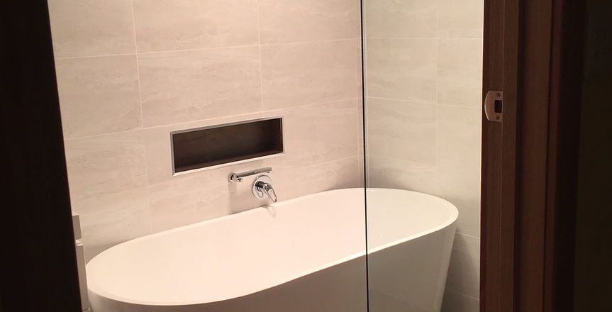 A bathroom with a bathtub and a shower stall.