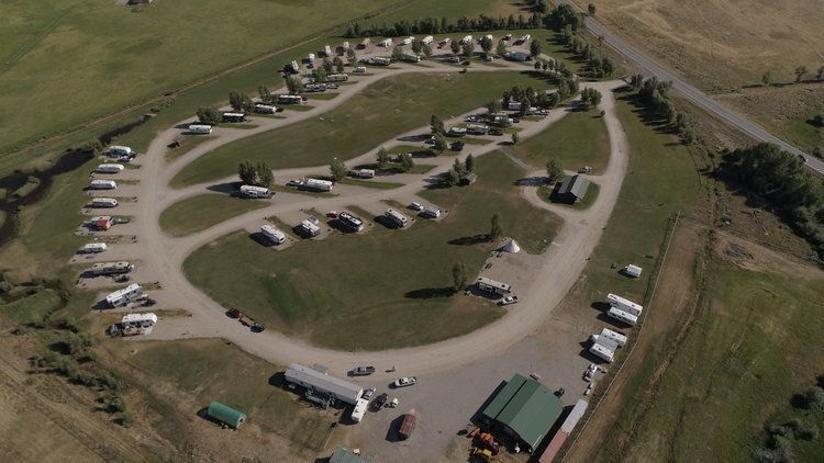 Aerial view of a trailer park with trailers arranged in a circular pattern on a grassy field.