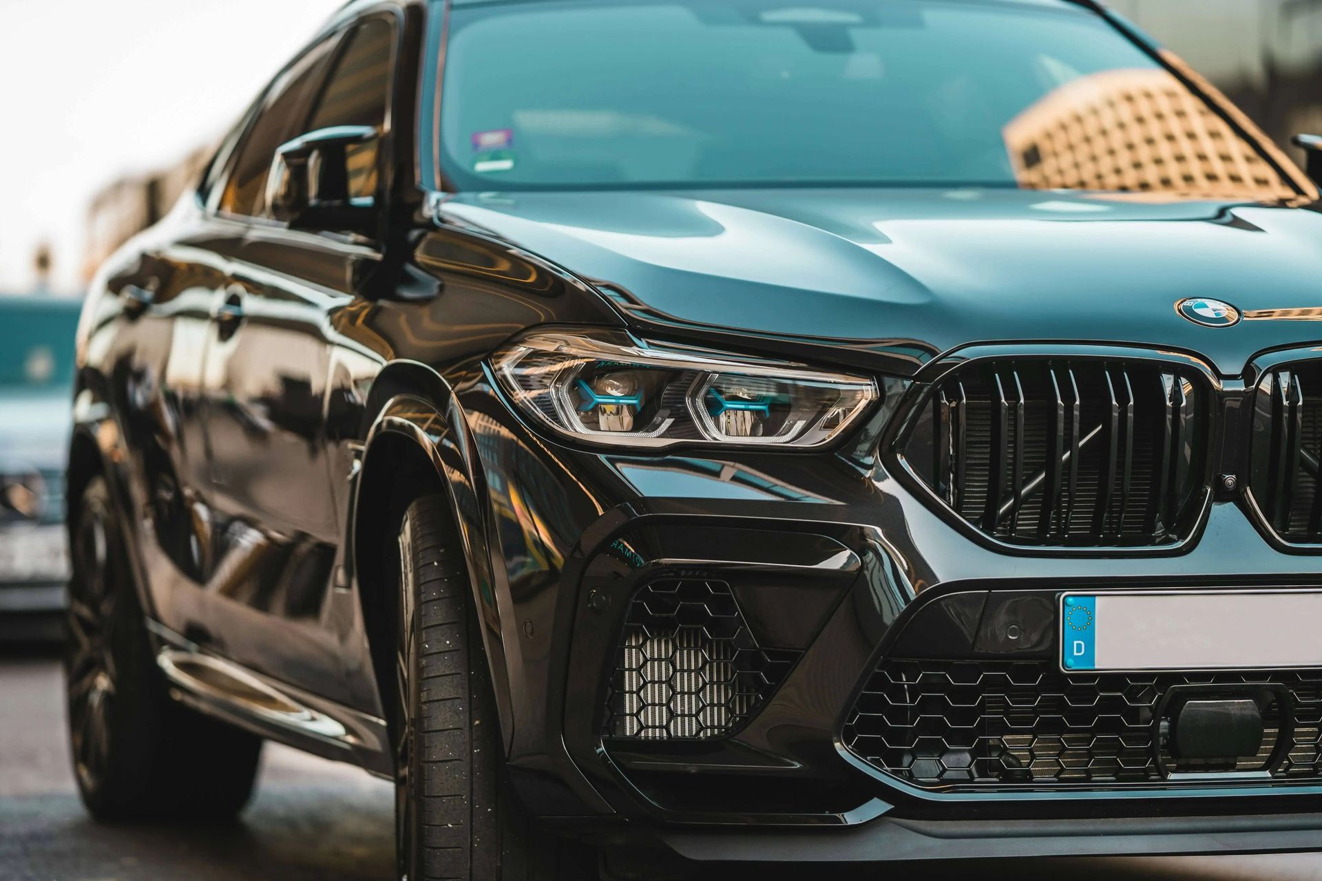 A black bmw x6 m is parked on the side of the road.