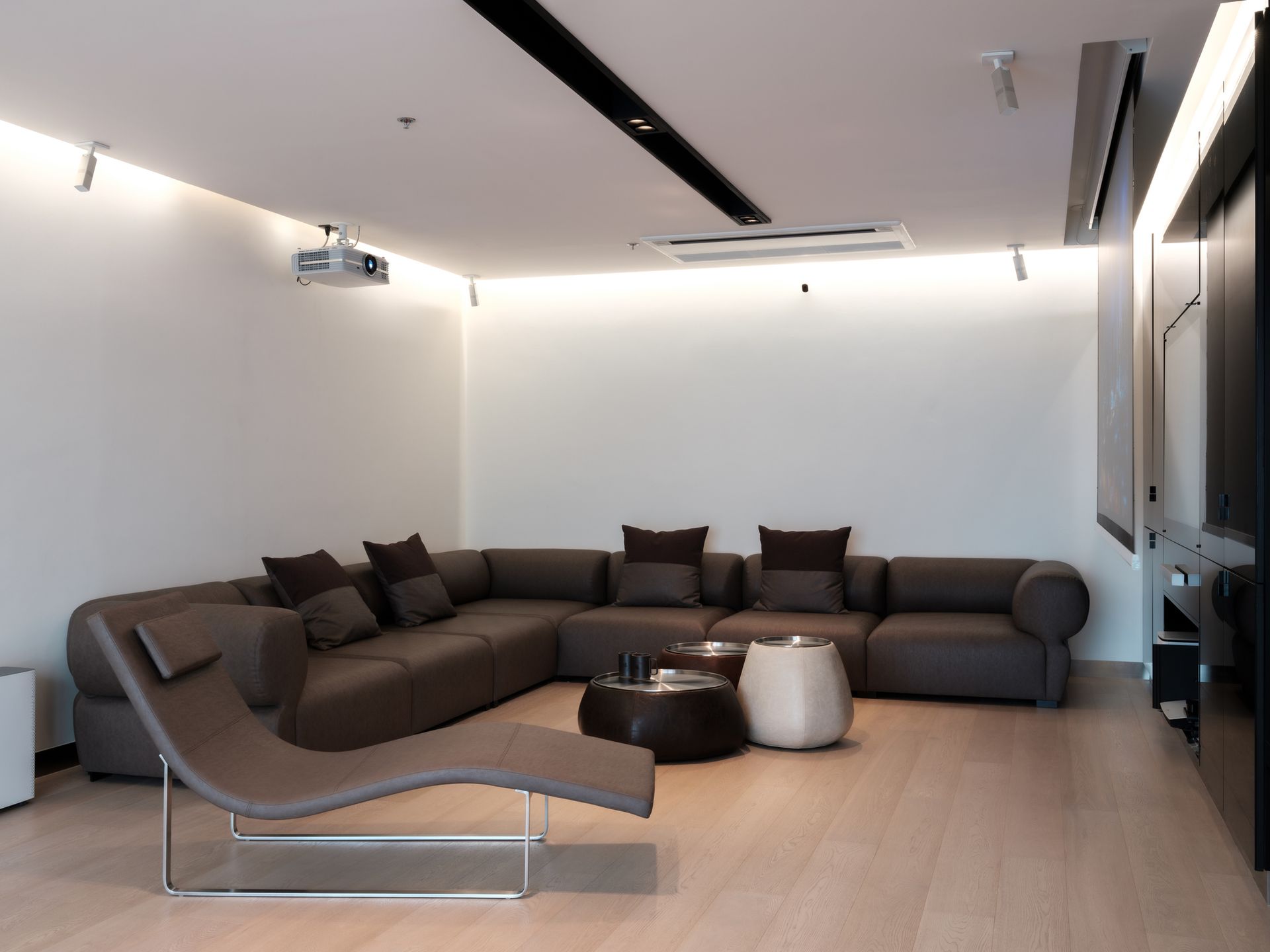 Modern living room with sectional sofa, chaise lounge, coffee tables, and projector. Modern living room with sectional sofa, chaise lounge, coffee tables, and projector.
