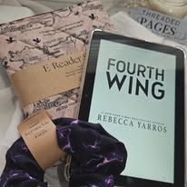 E-reader with "Fourth Wing" by Rebecca Yarros, book sleeve, and eye mask.