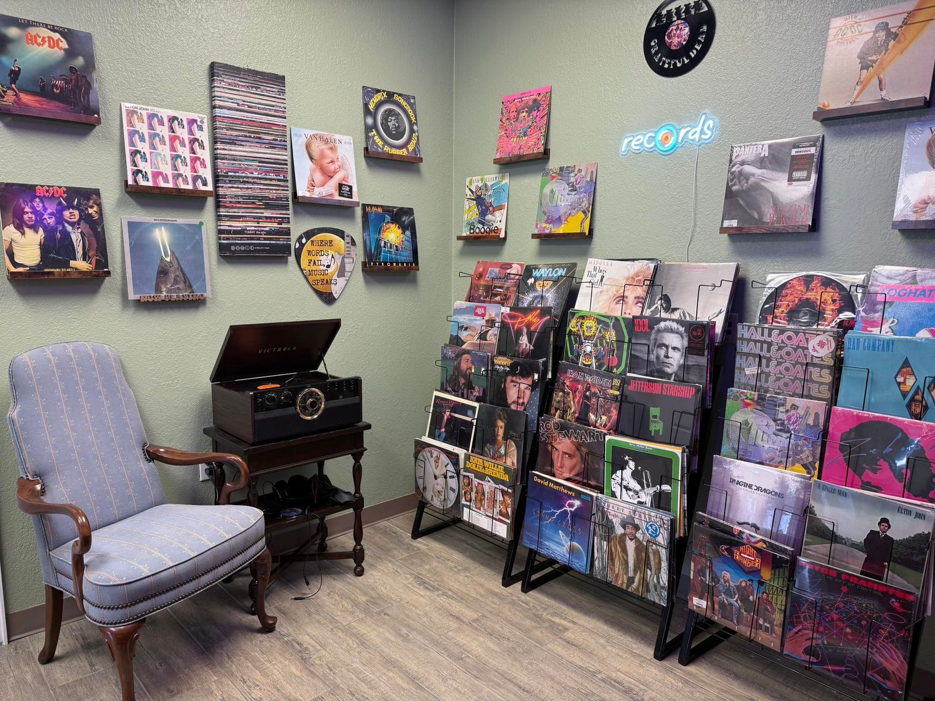 Record store interior with vinyl album displays, vintage player, and chair. 