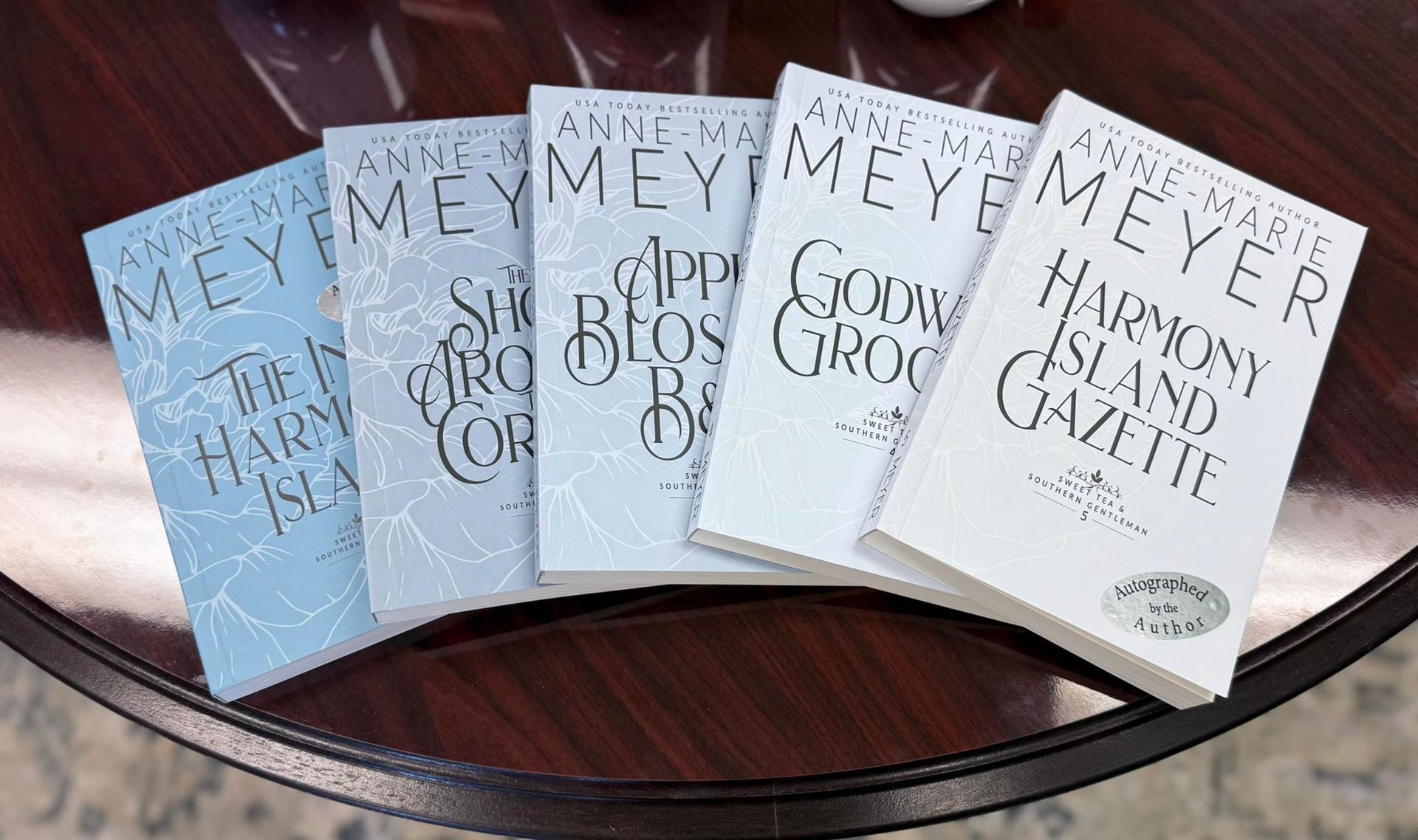 Five books titled "Harmony Island" by Anne Marie Meyer, fanned out on a table.