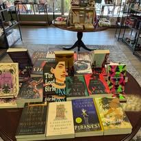 Books on a table: covers of various sizes and colors, in a bookstore or library.