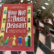 Book titled "How Not to Be a Basic Peasant" with dice on a decorative metal table.