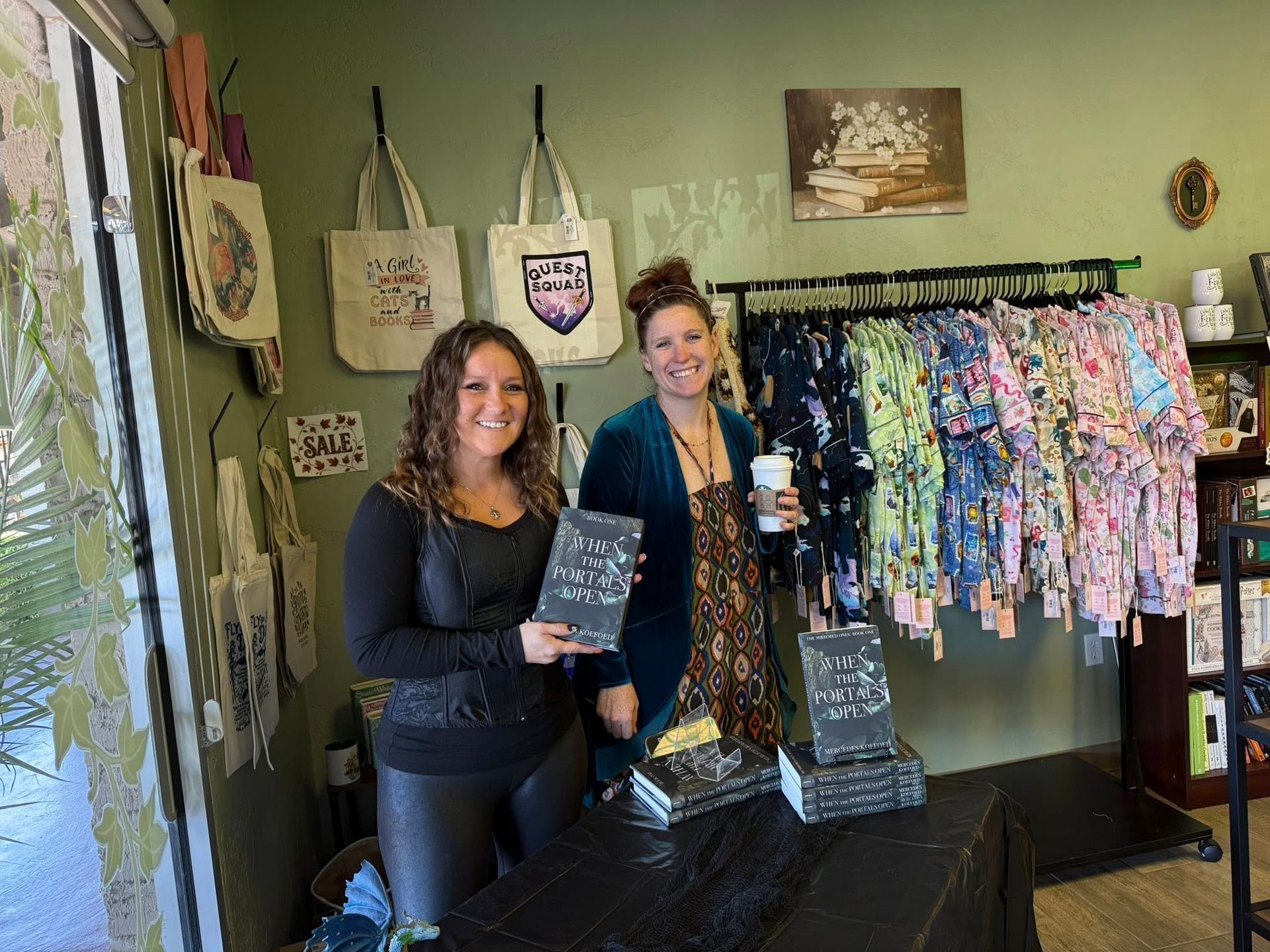 Woman holding small brown bag, smiling at a table with others. Snacks and books in the background.