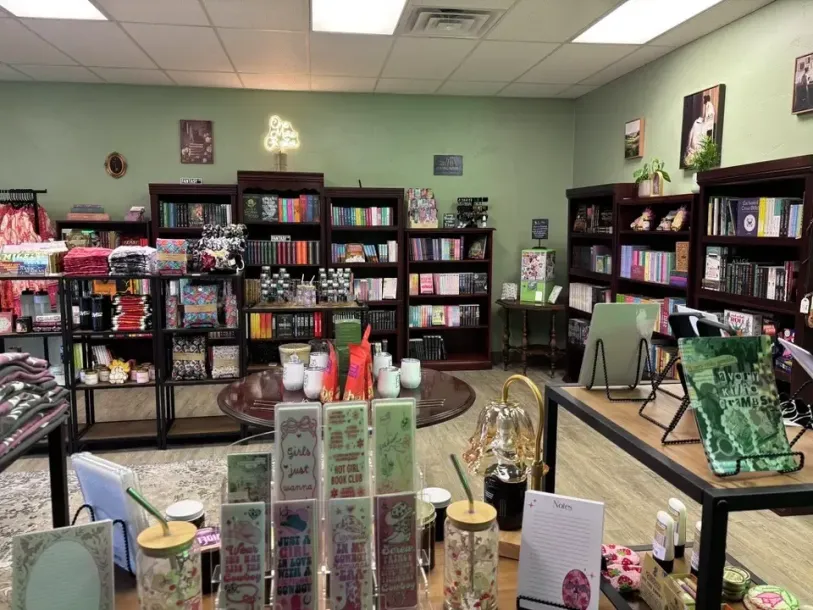 Interior of a book and gift shop with shelves of books, candles, and other merchandise.