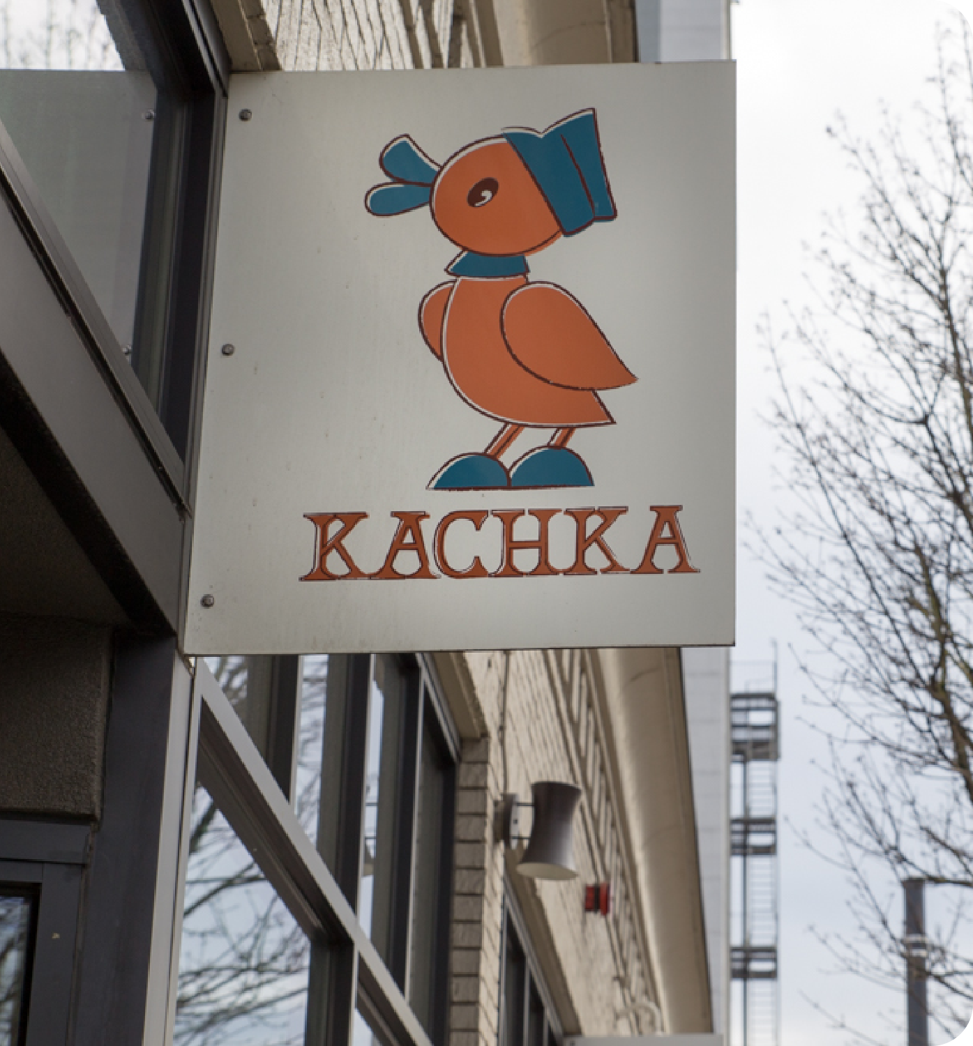 Sign for KACHKA with a colorful orange-and-blue bird logo on a building exterior
