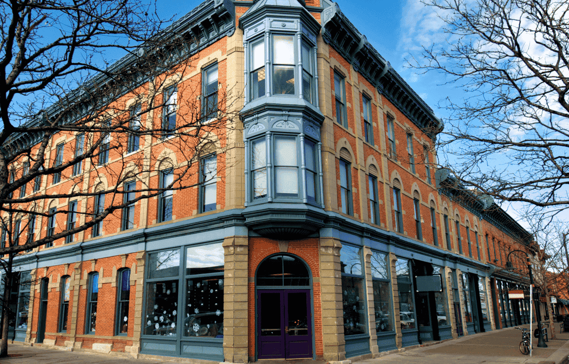 A large brick building with a purple door on the corner