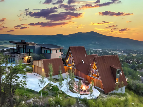 A large house in the Aspen snow with mountains in the background