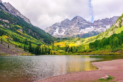 A lake in the middle of a mountain valley with mountains Maroon Bells hike in Aspen CO