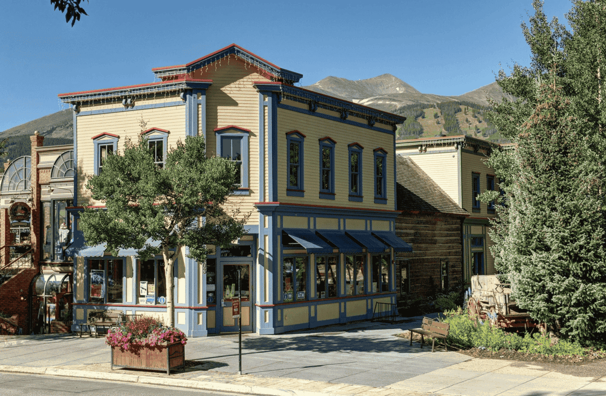 A yellow and blue building with a mountain in the background