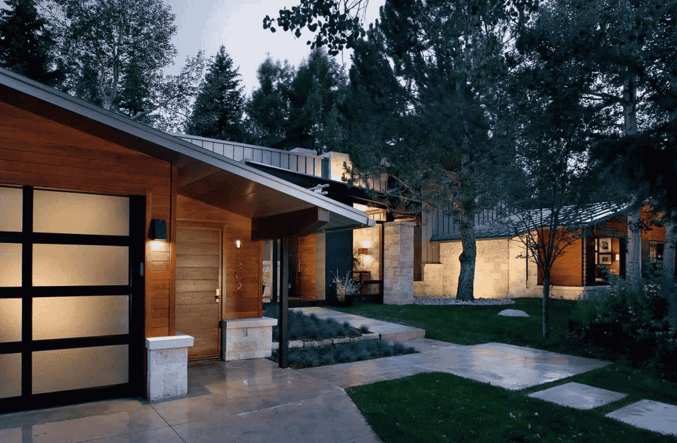 A house with a walkway leading to it and trees in the background