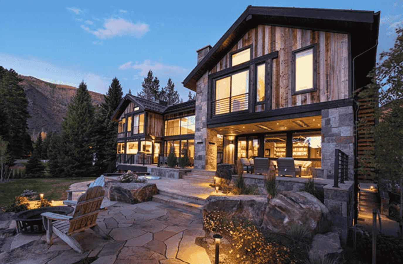 A large house with a lot of windows and a fire pit in front of it.