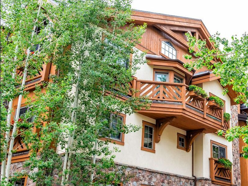A living room in an Aspen timeshare with a fireplace and a view of mountains