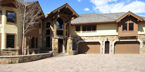 A large Vail Colorado mansion with two garages and a brick driveway