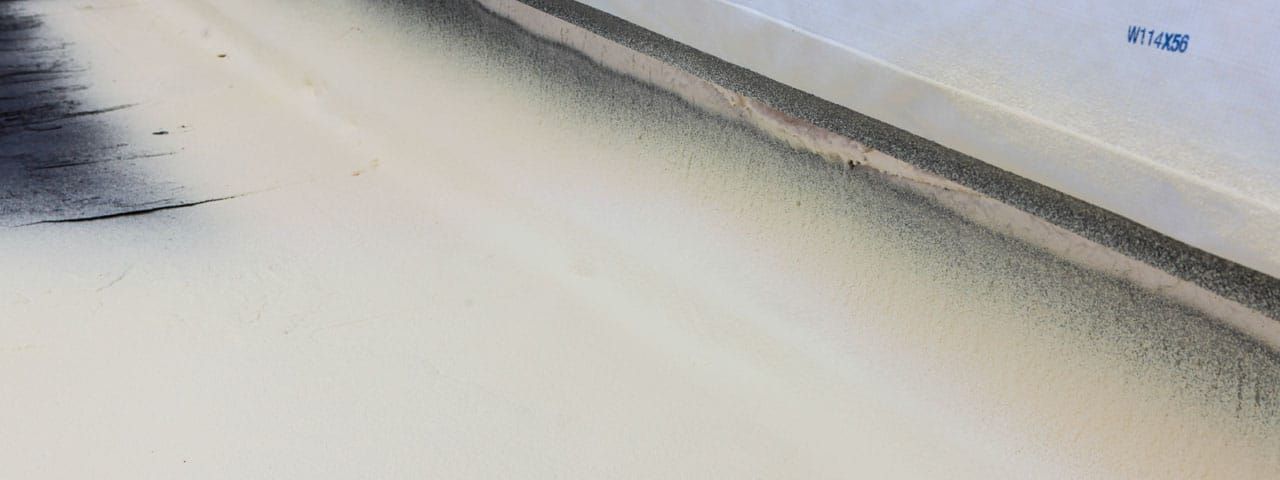 A close up of a white surface with black spots on it.