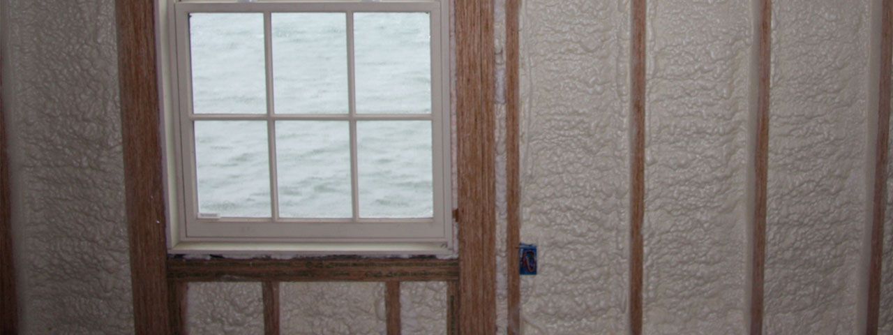 A room with a window and a wall covered in insulation.