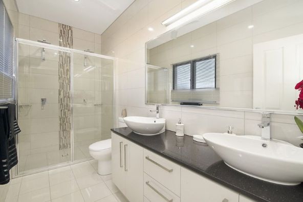 A Bathroom With Two Sinks, a Toilet and a Shower — Precision Shower Screens & Wardrobes In Yarrawonga, NT