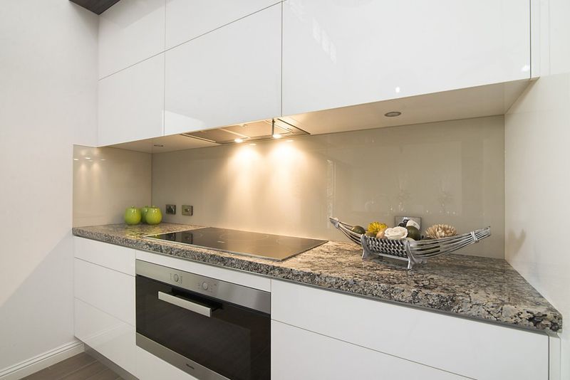 A Kitchen With White Cabinets, Granite Counter Tops — Precision Shower Screens & Wardrobes In Yarrawonga, NT
