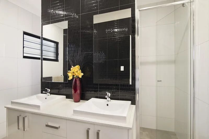 A bathroom with two sinks , a mirror and a walk in shower — Precision Shower Screens & Wardrobes In Yarrawonga, NT