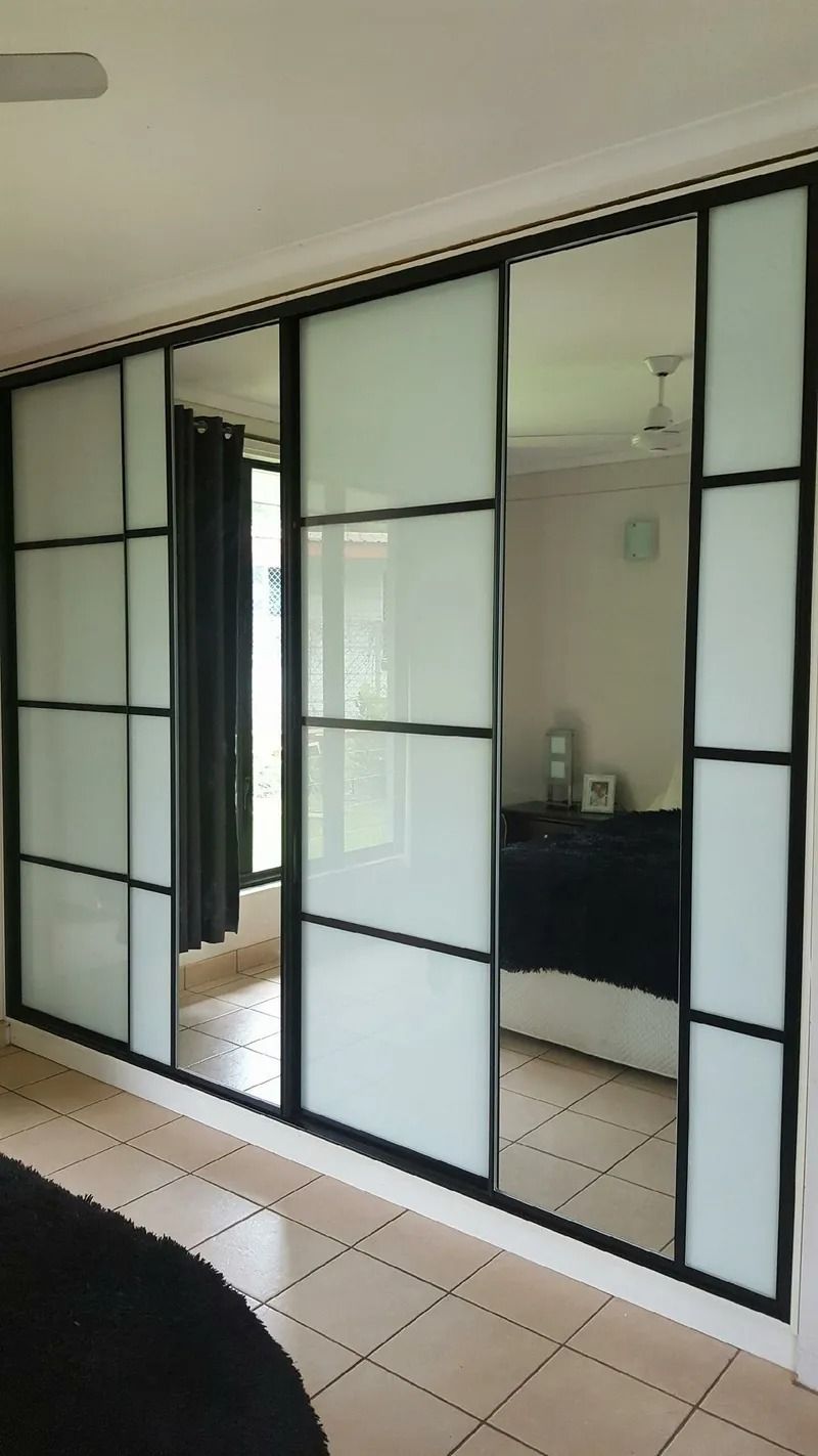 A bedroom with sliding glass doors and a bed — Precision Shower Screens & Wardrobes In Yarrawonga, NT