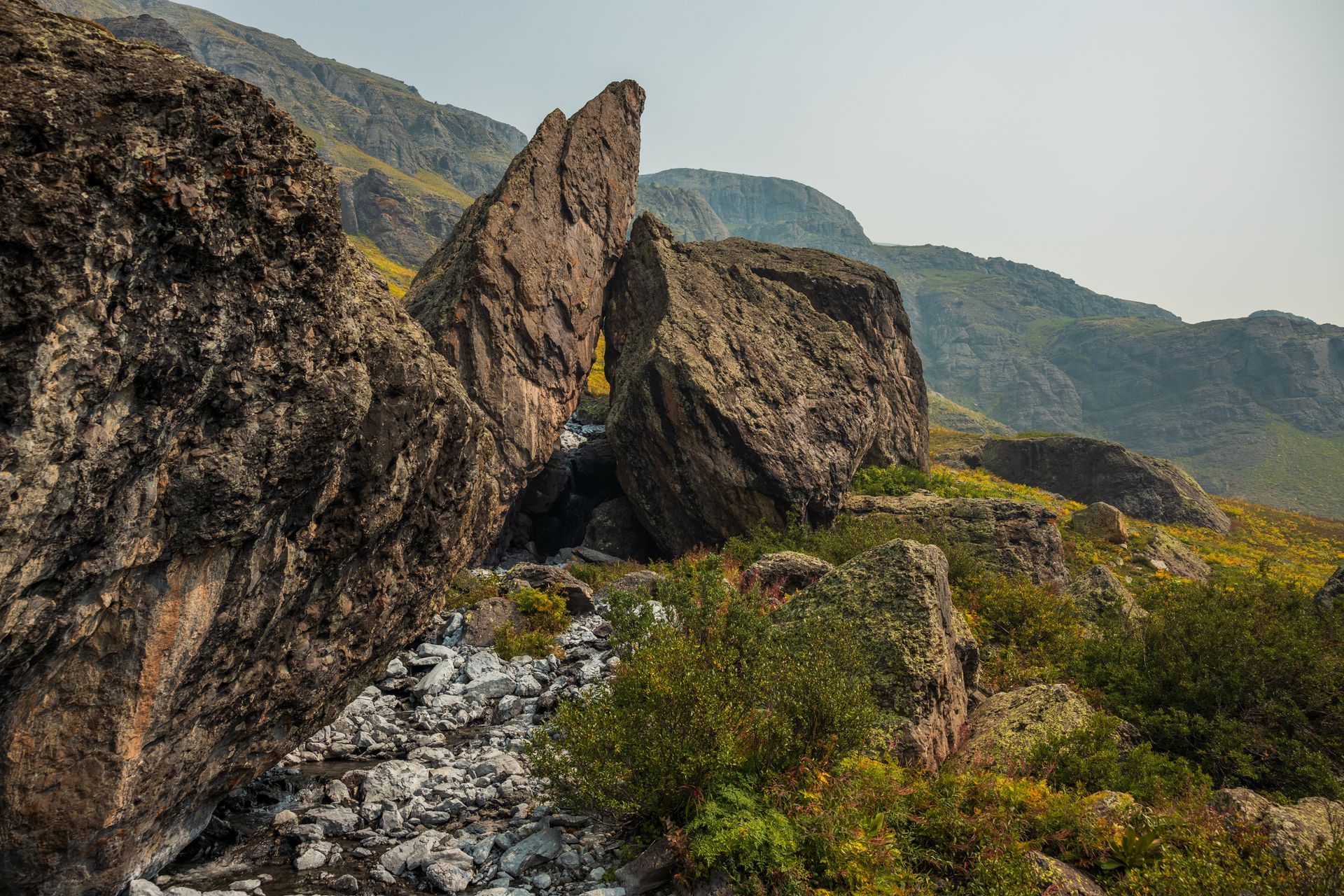 A river running through a rocky landscape with mountains in the background.