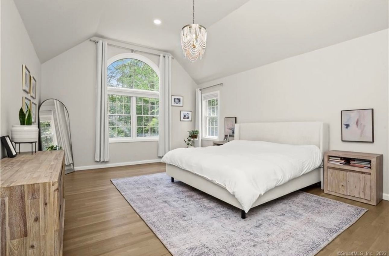 A bedroom with a bed , dresser , nightstand and rug.