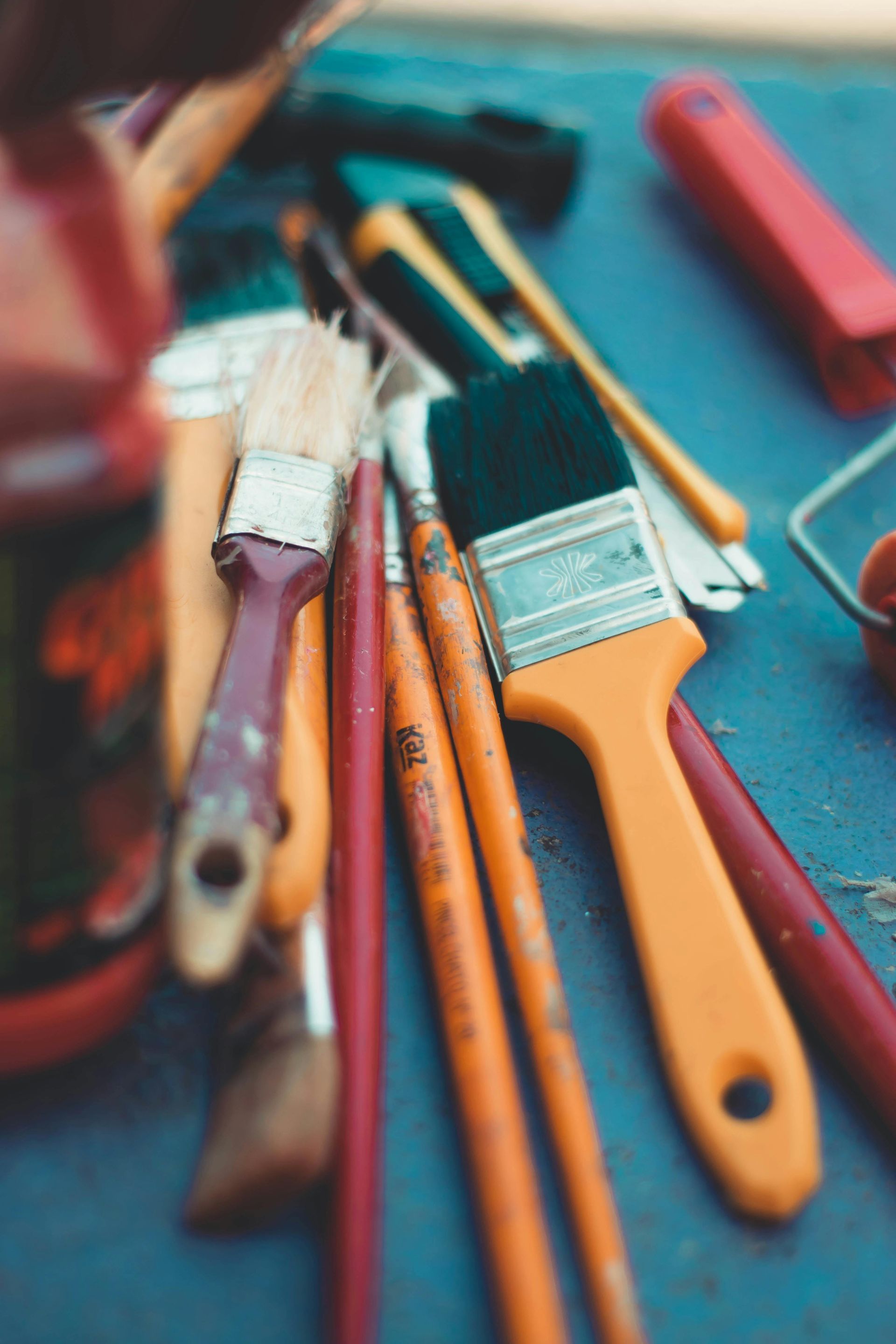 A bunch of paint brushes are sitting on a table.