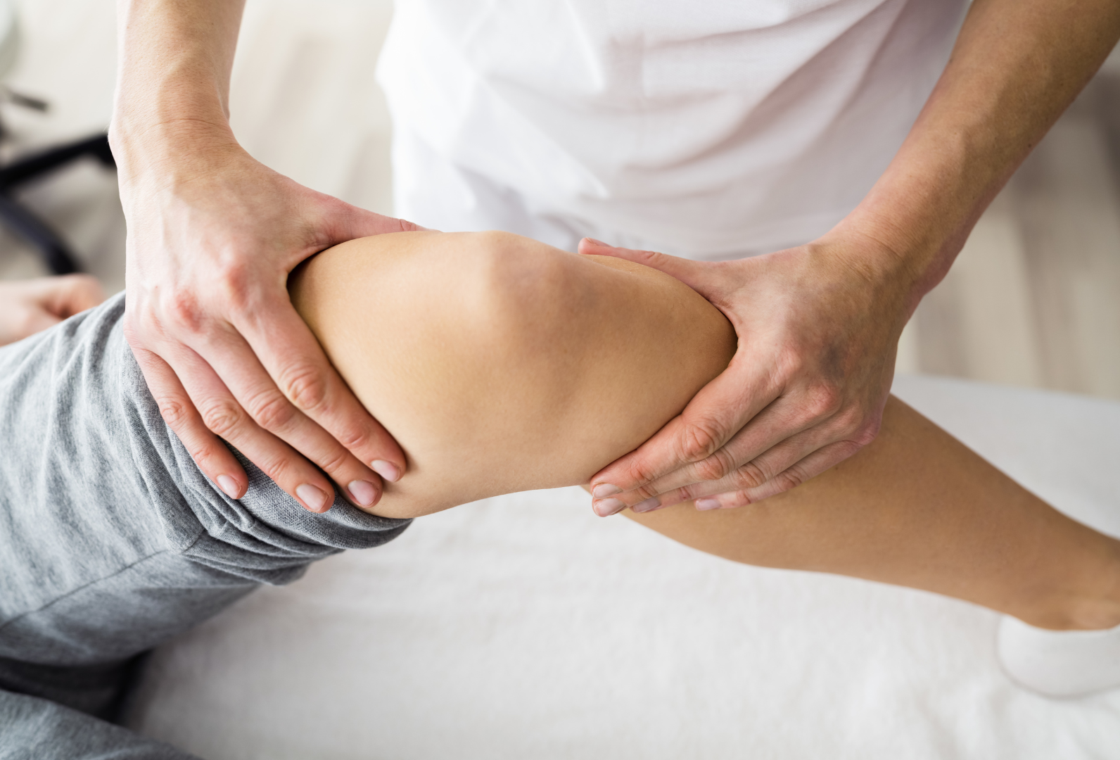 A man is laying on a table getting a massage from a nurse.