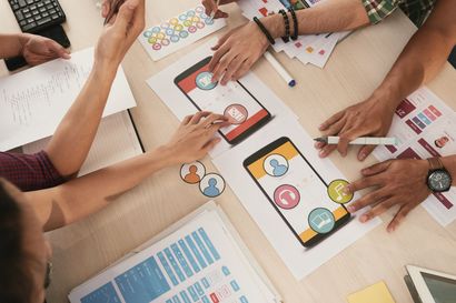 A group of people are sitting around a table working on a project.