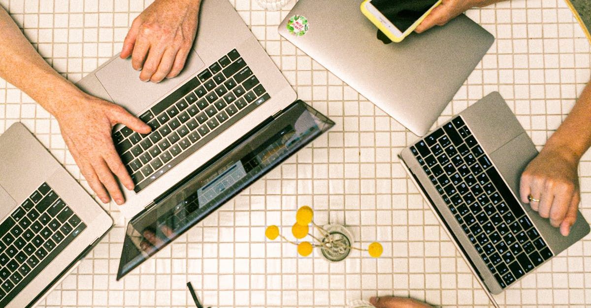 A group of people are sitting around a table using laptops.