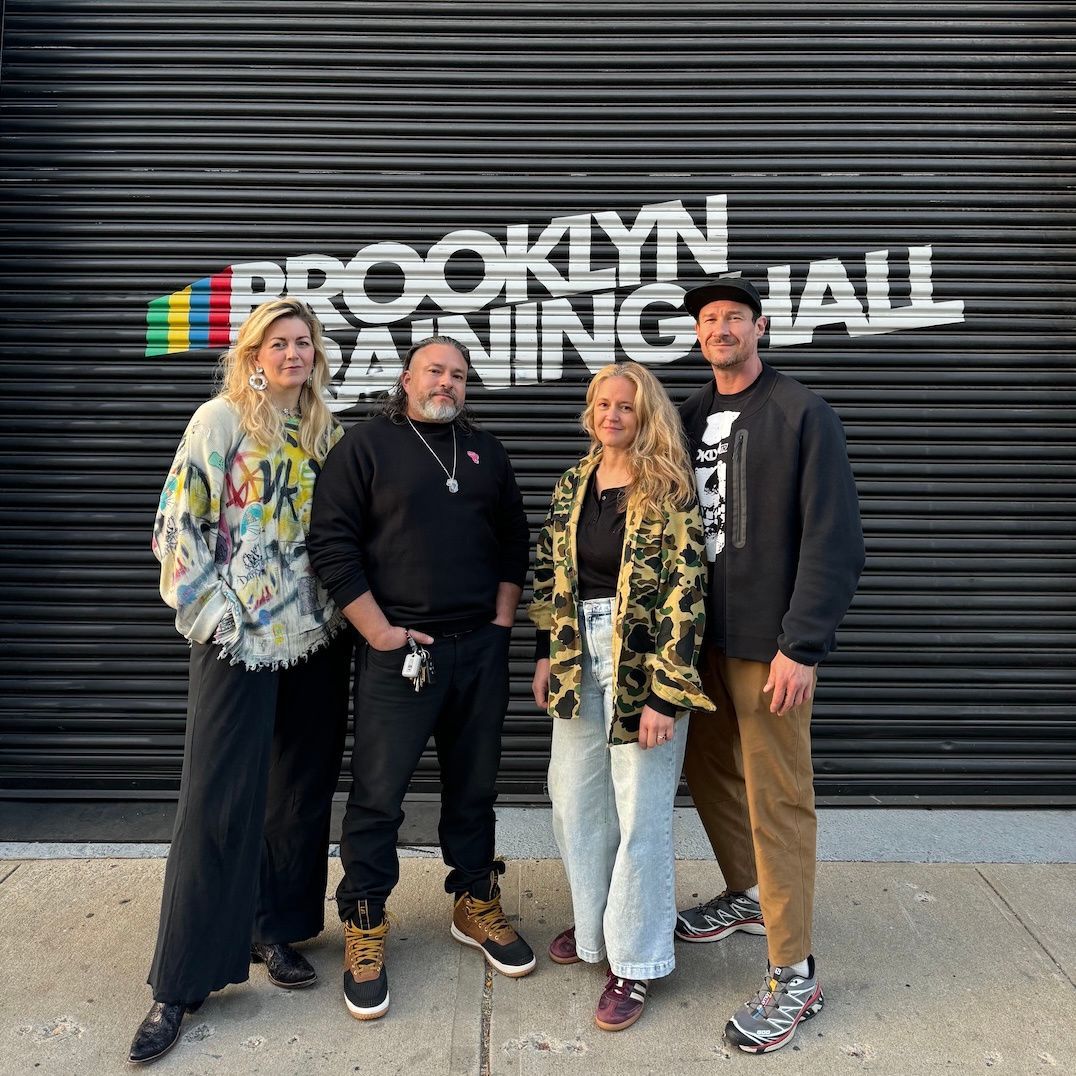 A group of people standing in front of a sign that says brooklyn gaming hall.