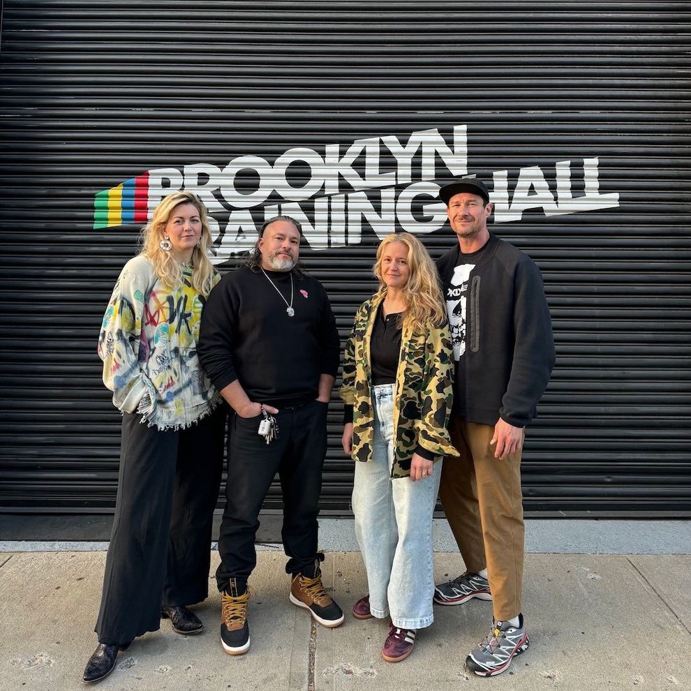 A group of people standing in front of a sign that says brooklyn gaming hall.