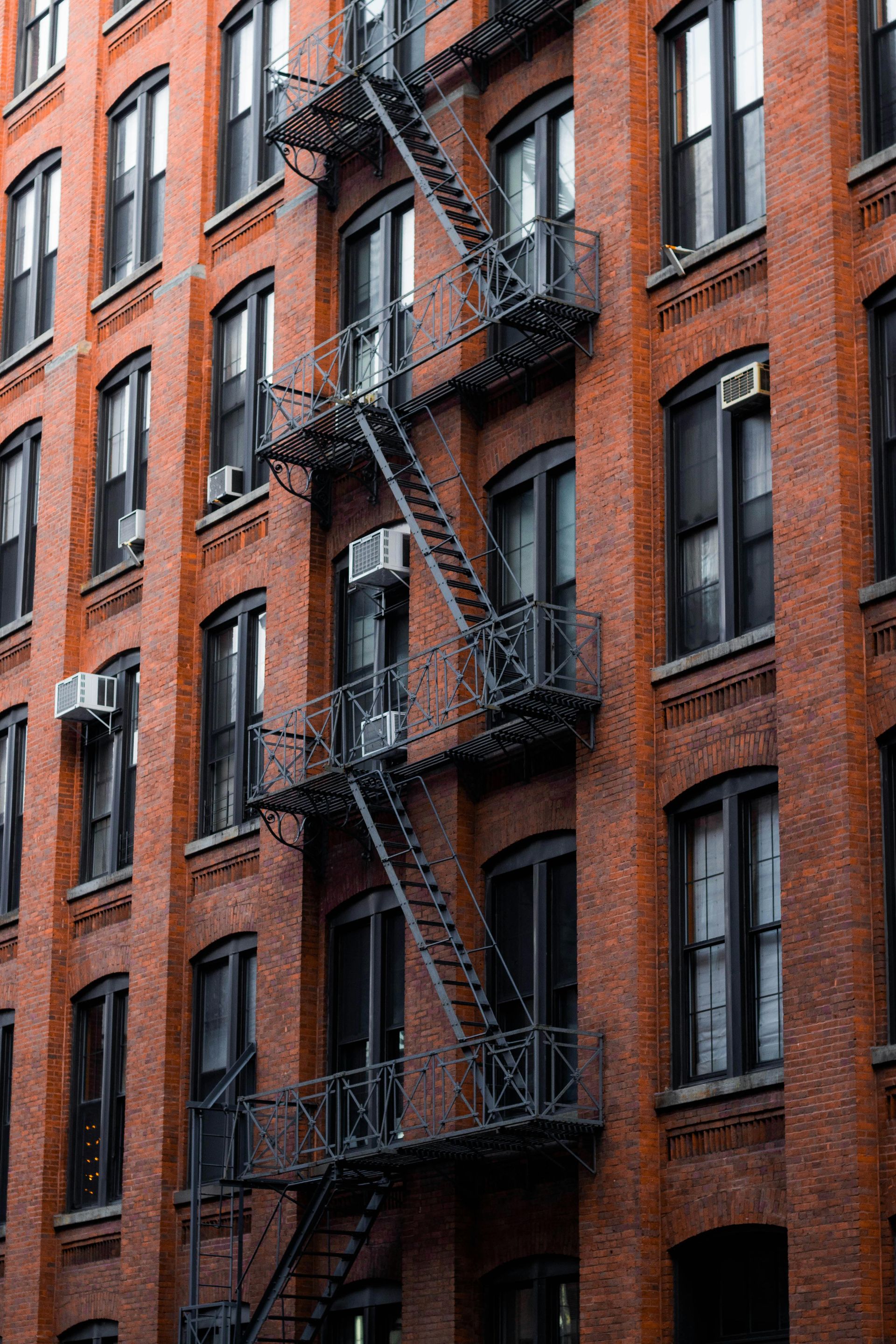 Red brick apartment building with a black metal fire escape.