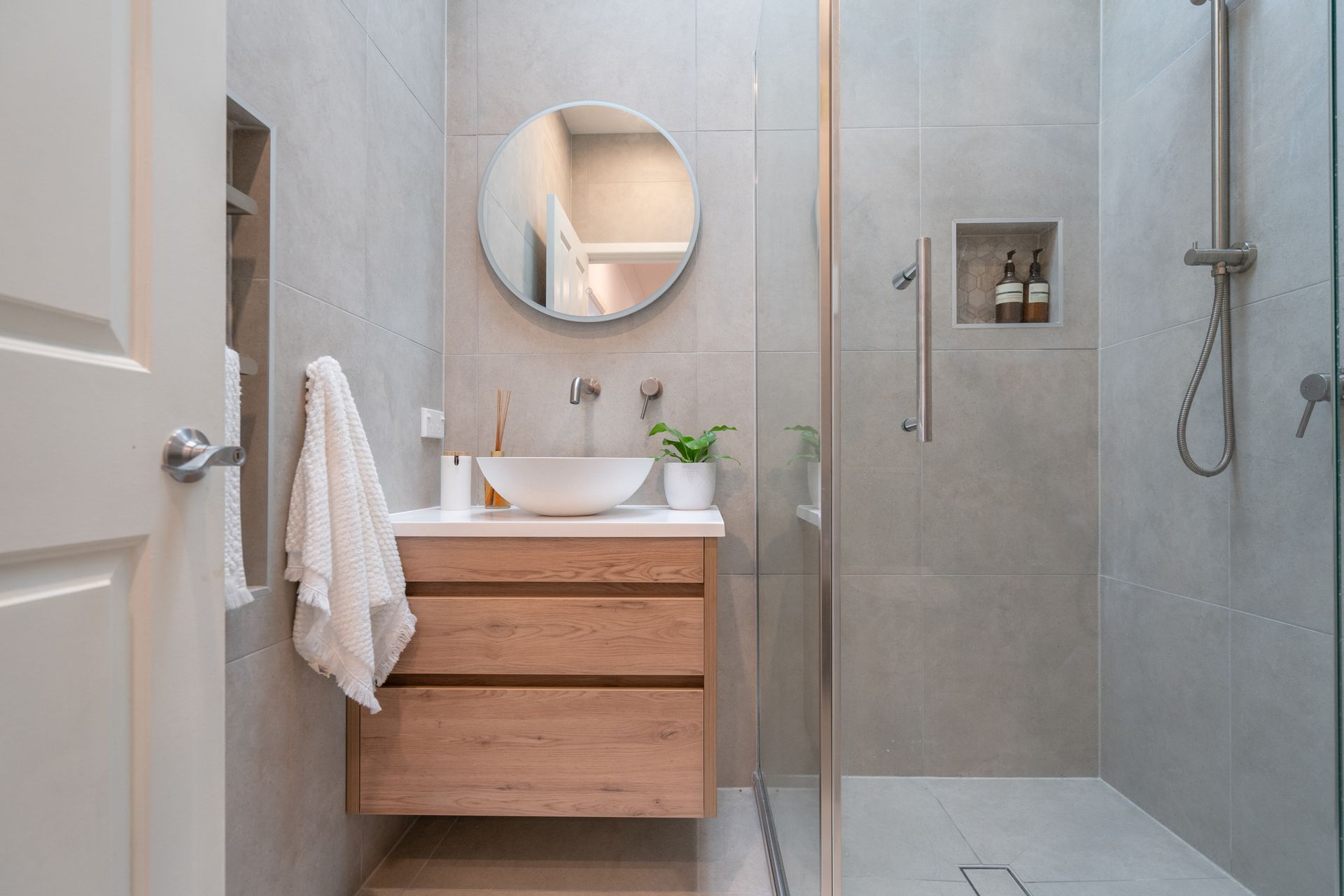 Un bagno con lavandino, specchio e cabina doccia.