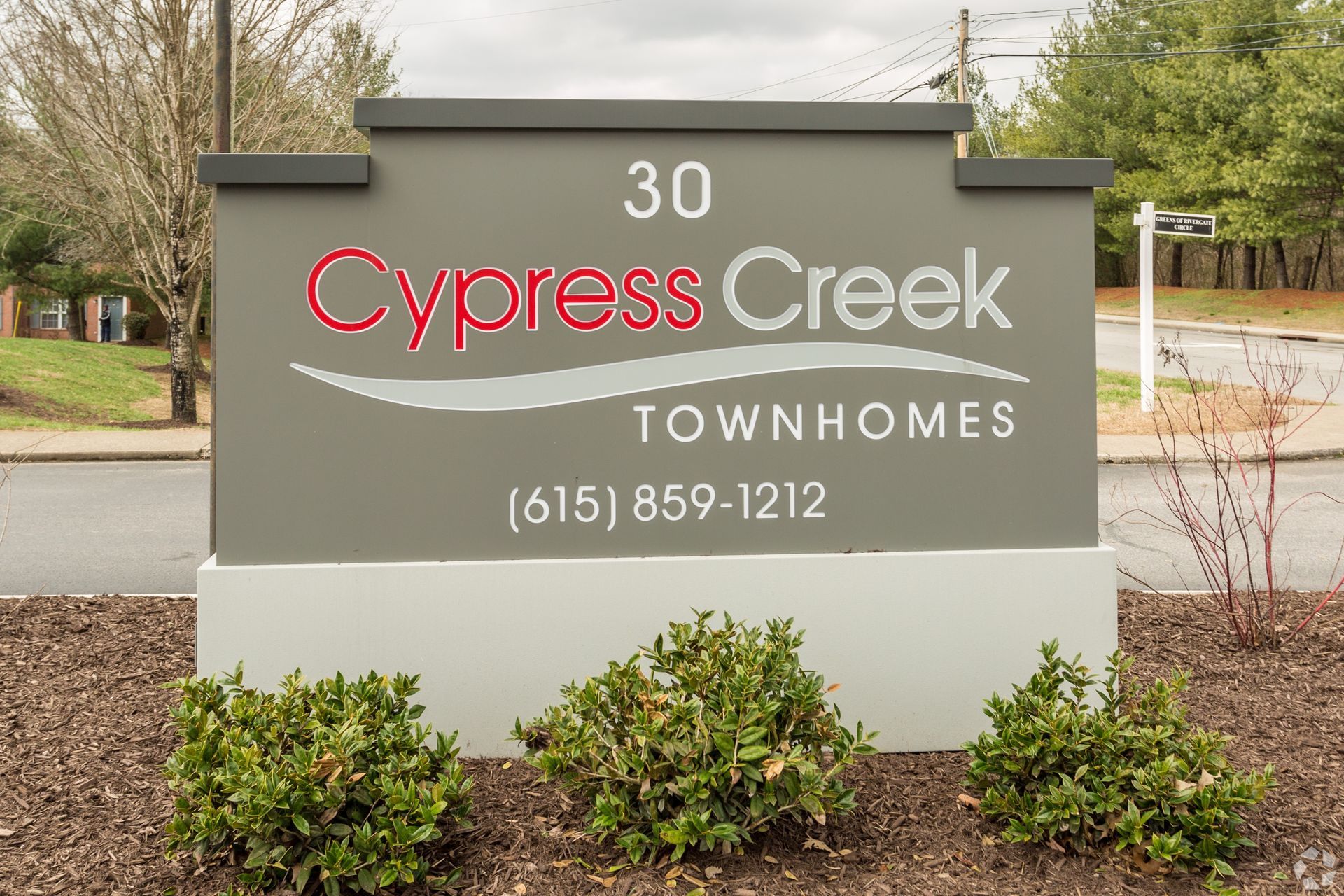 A sign for Cypress Creek Townhomes at 30, with the phone number (615) 859-1212, set in front of a landscaped lawn.